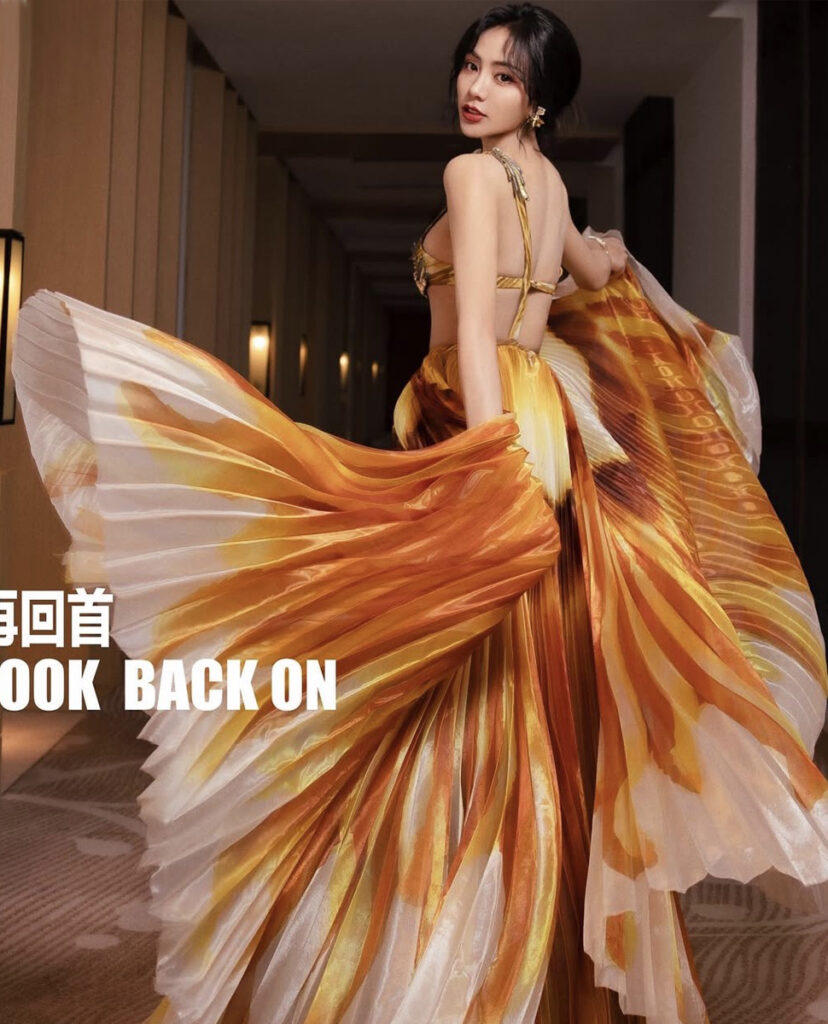 L'actrice et chanteuse Chloe Chaking porte une robe Haute Couture rouge orange gold par la maison On Aura Tout Vu