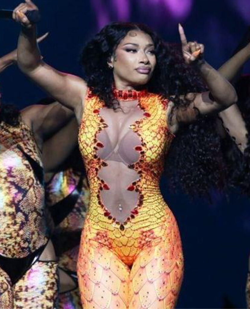 La rappeuse américaine MEGAN THEE STALLION porte une combinaison jaune et rouge a écailles géantes sur mesure de la maison de couture On Aura Tout Vu pour sa tourne.